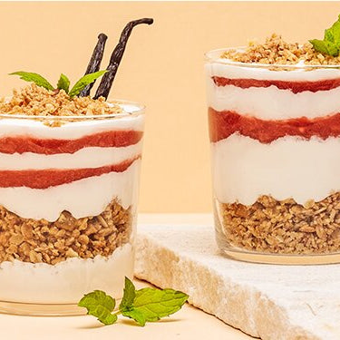 Erdbeer-Schicht-Dessert in einem Glas mit Erdbeeren daneben