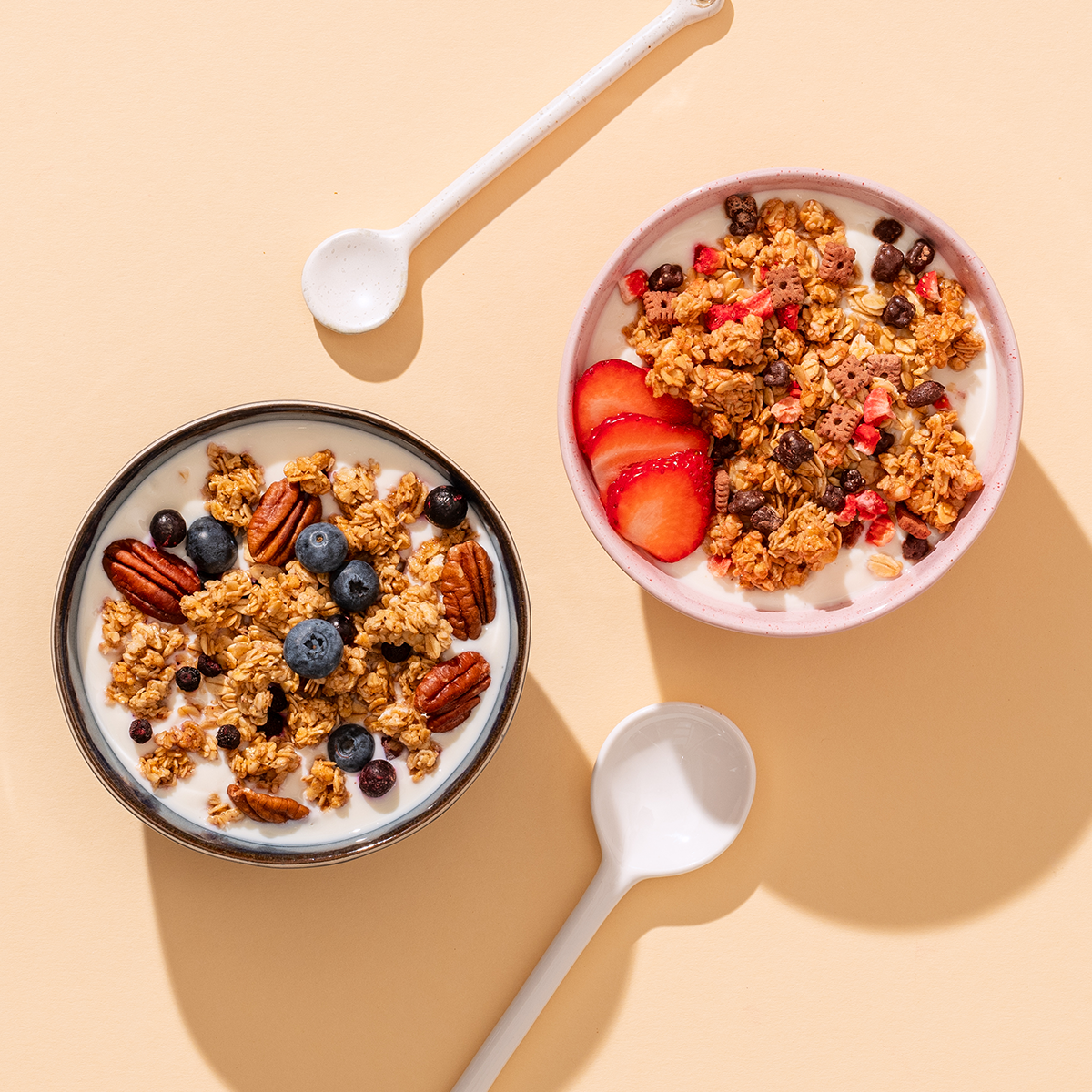 mymuesli Bio Crunchy Granola Probierpaket mit 2 leckeren Crunchy Granolas - hier in Schalen mit Milch und frischen Beeren