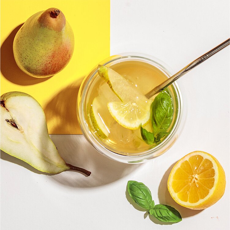 Grüner Birne Eistee mit Birnen und einer halben Zitrone daneben