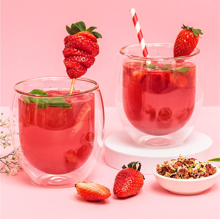 Erdbeer Rhabarber Cocktail mit einem Strohhalm und Tee daneben