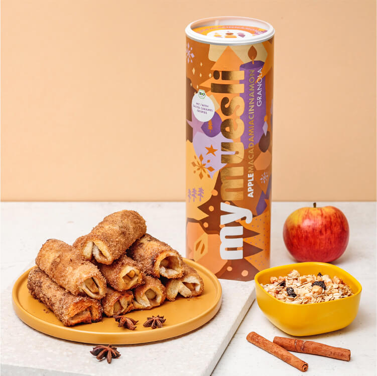 French Toast Roll Ups mit Apfel-Zimt Füllung auf einem Teller mit einer Müslidose daneben