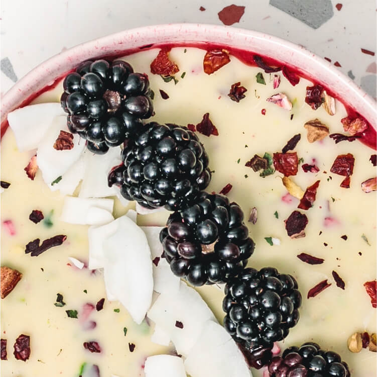 Magic Shell Smoothie Bowl mit Beeren und Kokoschips dekoriert
