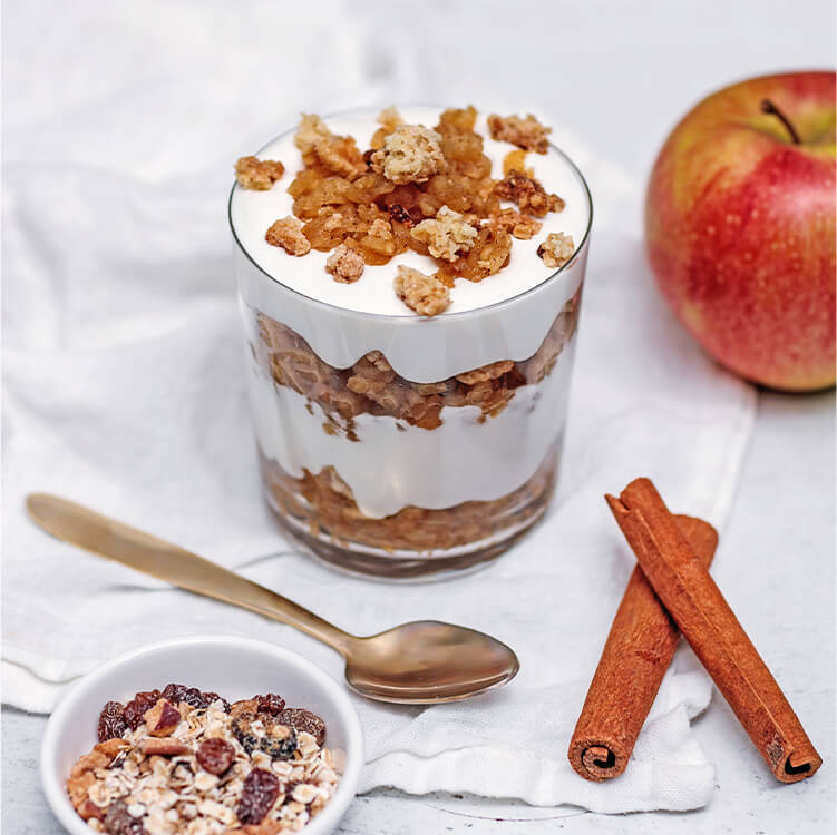 Schichtdessert mit Äpfeln und Zimtstangen
