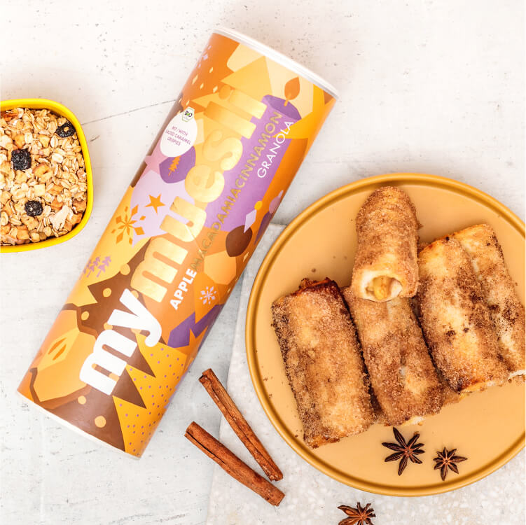 French Toast Roll Ups mit Apfel-Zimt Füllung auf einem Teller mit Müslidose daneben