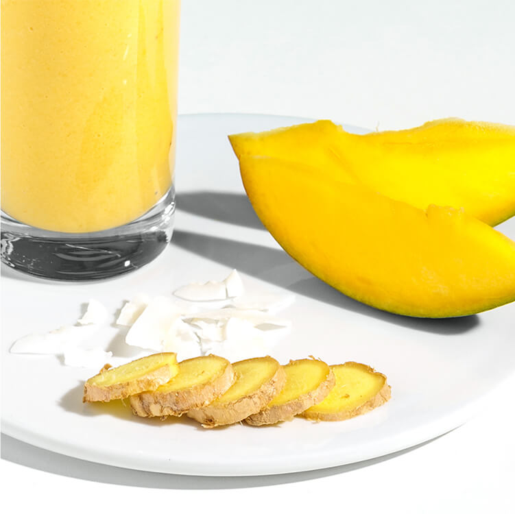 Bananen Smoothie auf einem Teller mit Mango und Ingwer