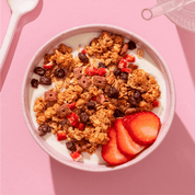 mymuesli Bio Strawberry Choco Crunchy Granola in Schale mit Joghurt und frischen Erdbeeren