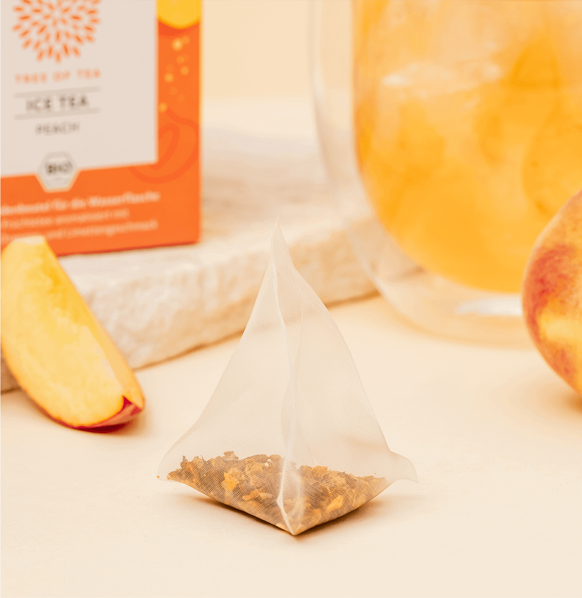 Tree of Tea Ice Tea Peach Beutel neben einem Stück Pfirsich