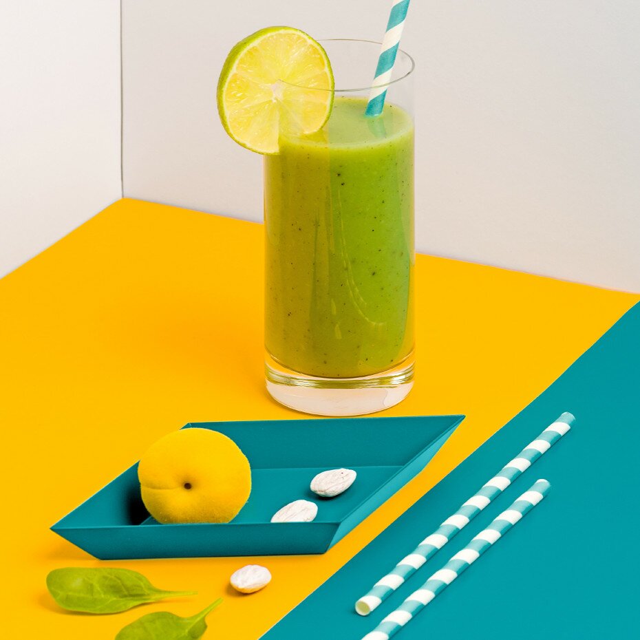Green Smoothie in einem Glas mit einer halben Limettenscheibe dekoriert