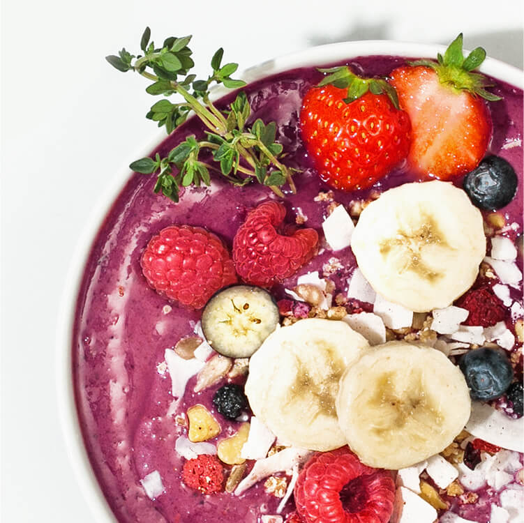 Acai Smoothie Bowl mit Bananenscheiben und Beeren dekoriert