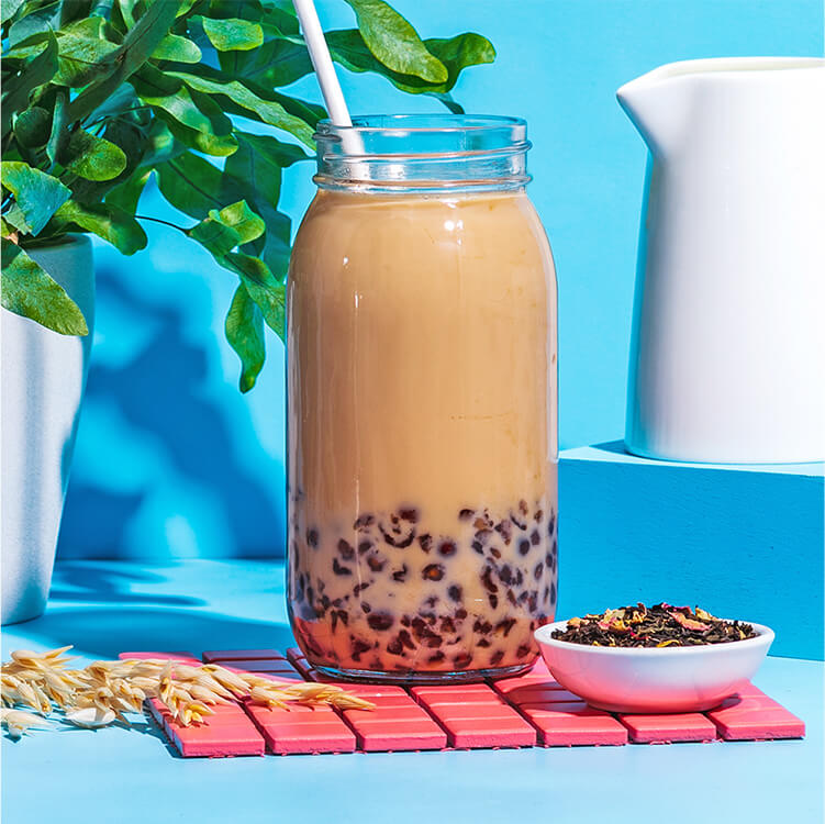 Bubble Tea in einer Flasche mit Tee daneben