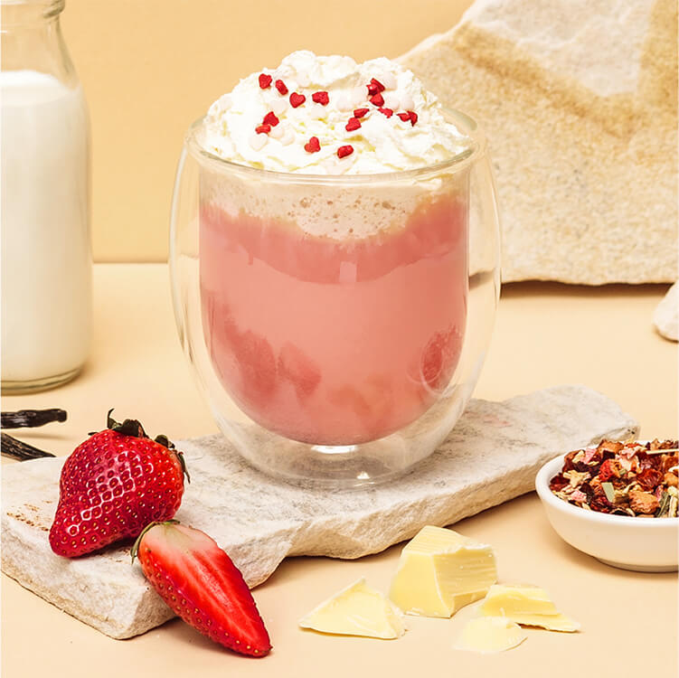 Pink Hot Chocolate mit Sahne und Erdbeeren daneben
