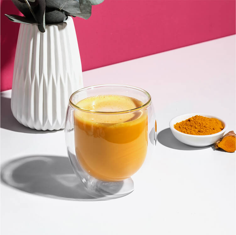 Kurkuma Latte mit Kurkuma daneben