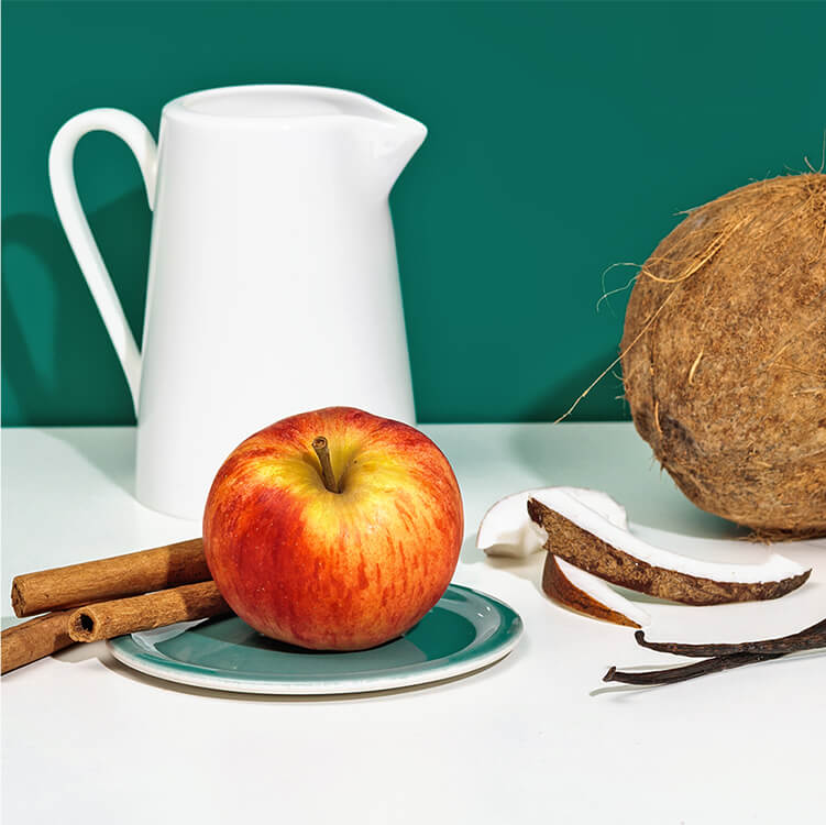 Ein Apfel, Zimtstangen und eine Kokosnuss