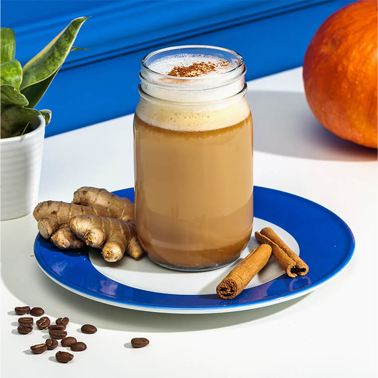 Pumpkin Spice Latte mit Zimtstangen und Ingwer dekoriert