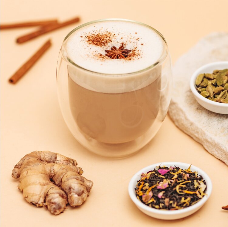Chai Tea Latte mit Gewürzen daneben