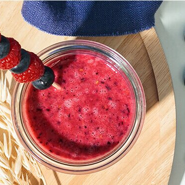Frühstücksdrink mit Beeren und Obstspieß