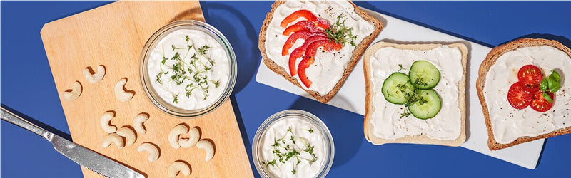 Cashew Frischkäse Sandwiches auf einem Teller mit Cashews daneben