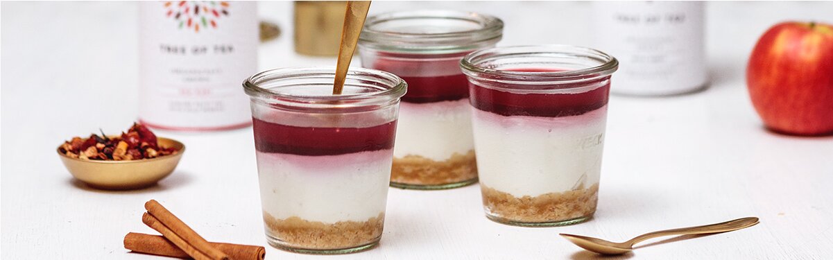 Cheesecake im Glas mit Tee-Topping und goldenem Löffel