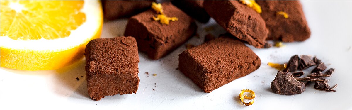 Schokoladenkonfekt mit Miss Grey und einer halben Orange daneben