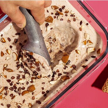 Bananen Mandel Nicecream in einem Glasbehälter und Waffeln daneben