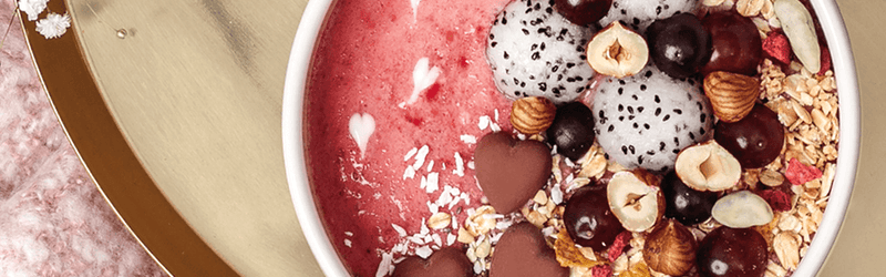 Himbeer-Smoothie-Bowl mit Drachenfrucht und Nüssen als Topping