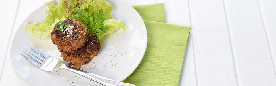Fleischpflanzerl auf einem Teller und Gabel