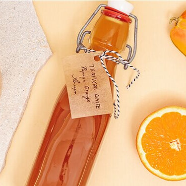 Tropical White Sirup mit Papaya und Orange daneben