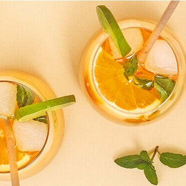 Tropical White Limonade mit einer halben Orange, Papaya und Limette