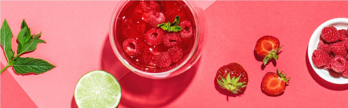 Minty Ruby in einem Glas mit Himbeeren und einer halben Limetten