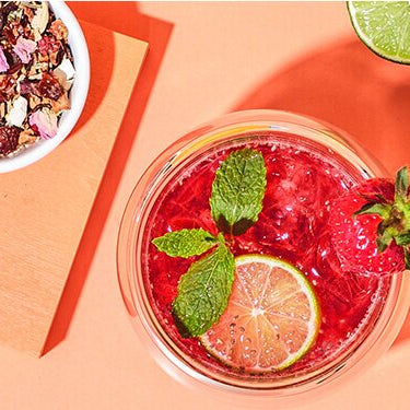 Erdbeer Chia Eistee im Glas mit einer Schüssel Chia Samen