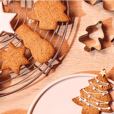 Christmas Cookies auf Tellern mit Ausstechförmchen daneben