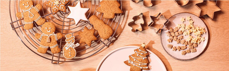 Christmas Cookies auf Tellern mit Ausstechförmchen daneben