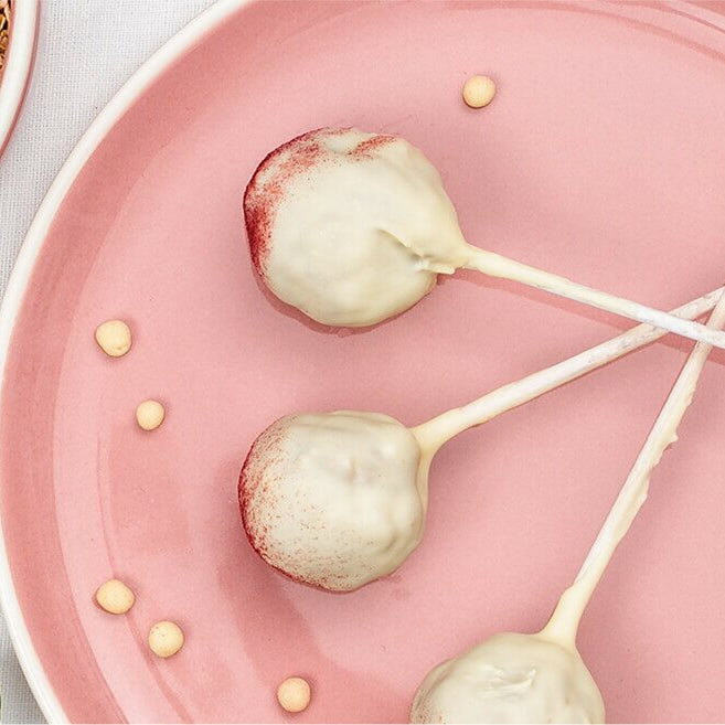 Müsli-Cake-Pops auf einem Teller mit Spießen