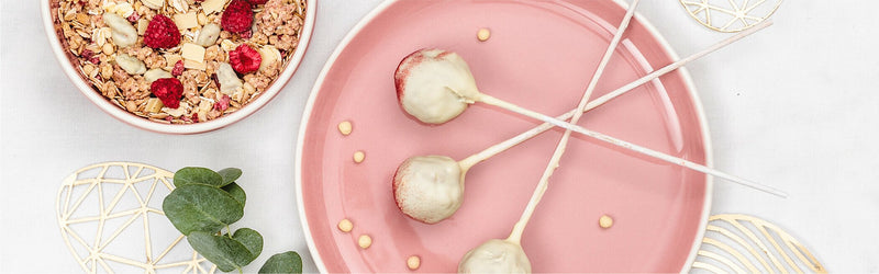 Müsli-Cake-Pops auf einem Teller mit Spießen