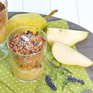 Müsli-Birnen-Crumble im Glas mit Birnen auf einem Tisch