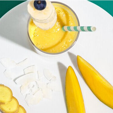 Bananen Smoothie mit einem Strohhalm auf einem Teller