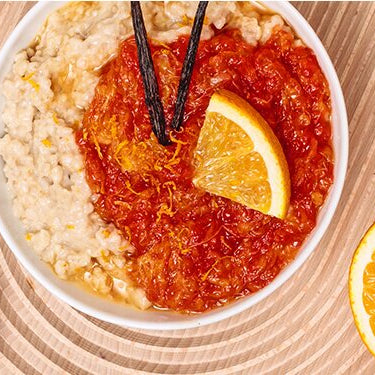 Miss Grey Porridge mit einer halben Orange und einer Schüssel Tee daneben