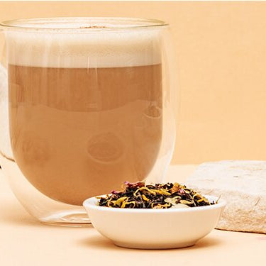 Chai Tea Latte mit Gewürzen daneben
