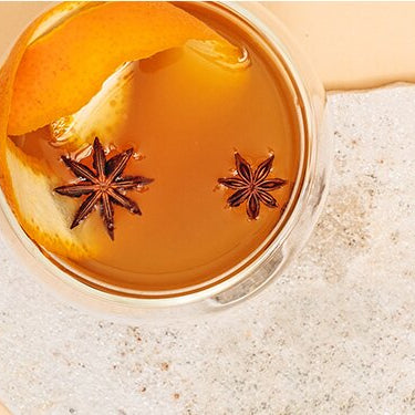 Sencha Mango Punsch mit Gewürzen und einer halben Orange