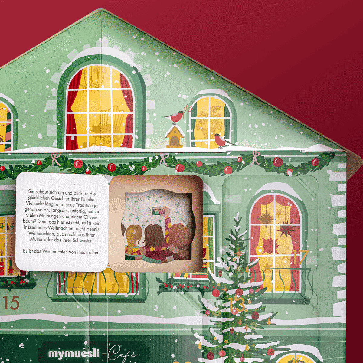 Nahaufnahme des rotes Adventskalenderhaus. Die Fenster des Hauses sind beleuchtet. Ein Türchen ist geöffnet und zeigt die Innenseite des Kalenders. In der Tür steht ein Teil der Weihnachtsgeschichte. Diese ist als Bild auf der Rückwand des Hauses.