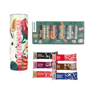 Ein mymuesli -Set auf grünem Grund: Eine bunt gemusterte Dose, eine Riegel-Box und sechs verschiedene Bio-Müsliriegel.