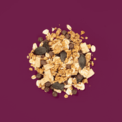 Ein Müsli Haufen mit Kürbiskernen, Haferflocken und weißer Schokolade.