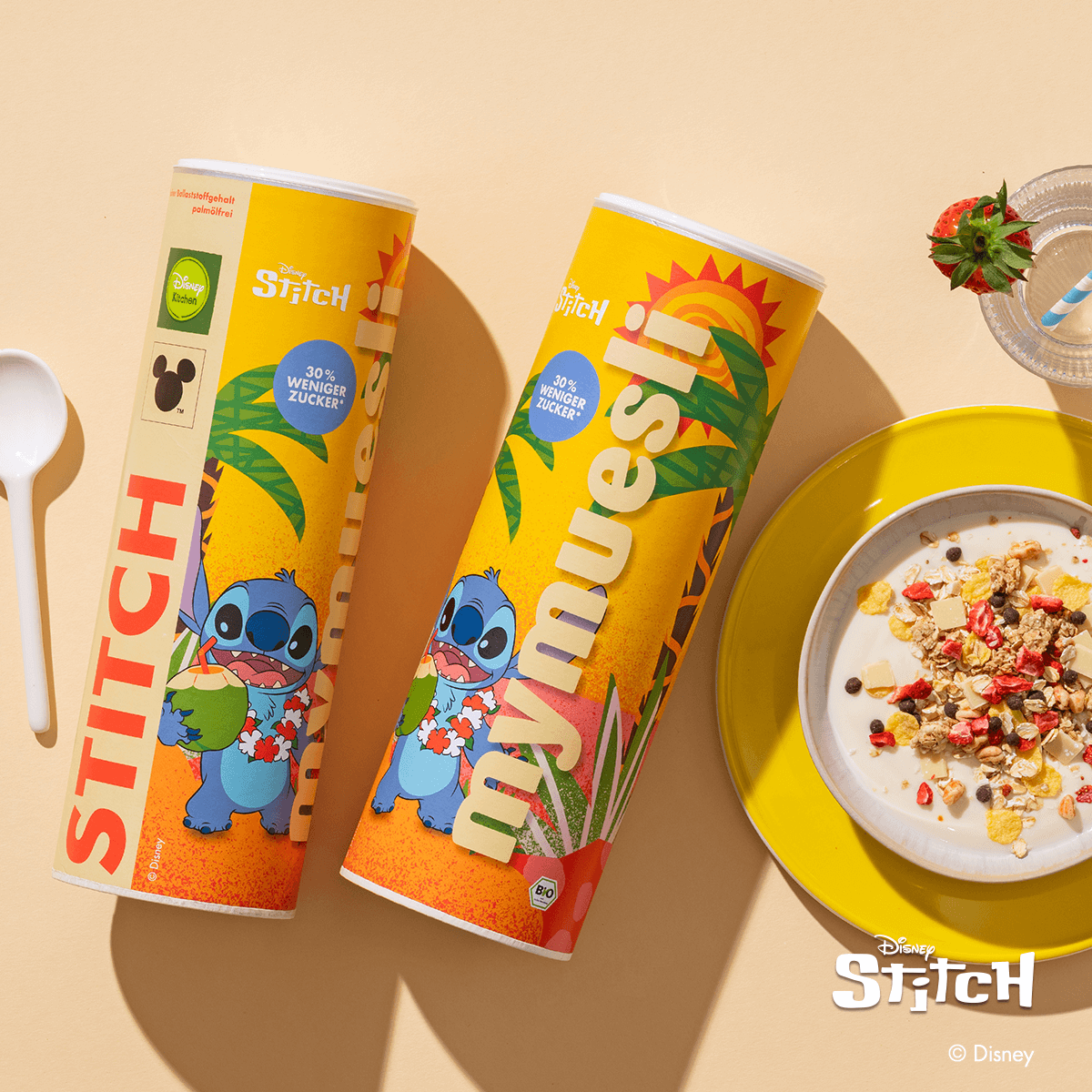 Disney Stitch Müsli Dosen und einer Schale Stitch Müsli daneben mit Erdbeerstückchen, Cornflakes und dunklen Schokodinkelbällchen