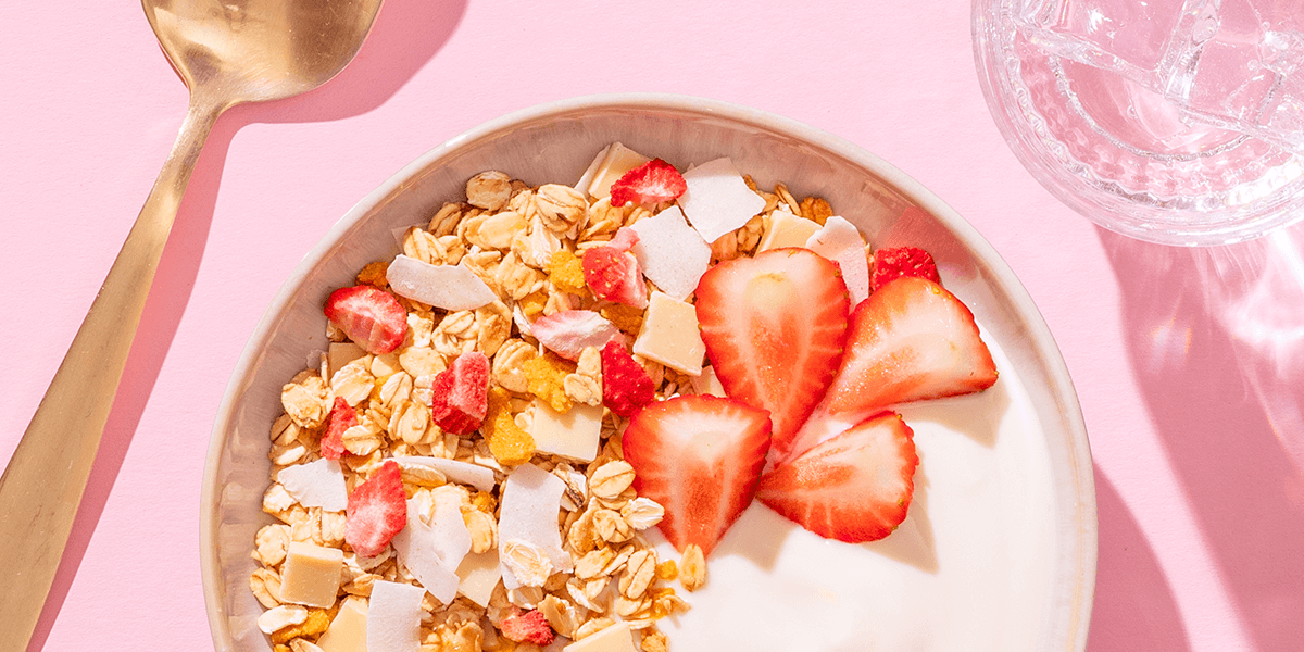 mymuesli Bio Sommer Müsli serviert mit Joghurt und frischen Erdbeeren
