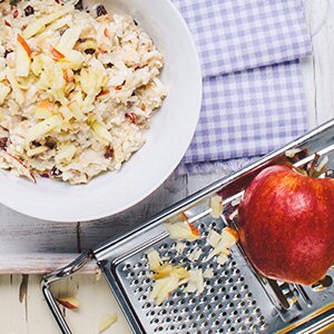 Eine Schale Oster-Bircher-Müsli mit einem geriebenen Apfel