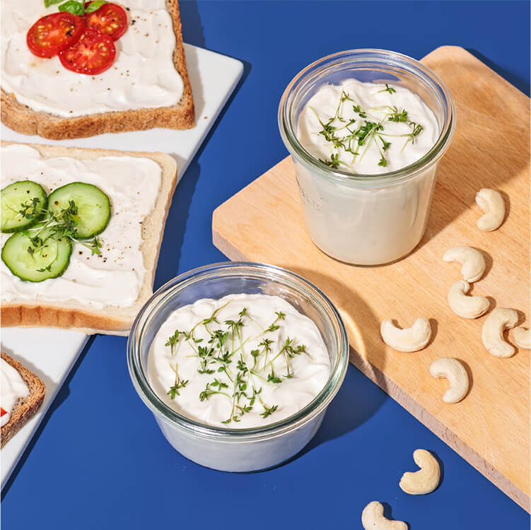 Cashew Frischkäse Sandwiches auf einem Teller mit Cashews daneben