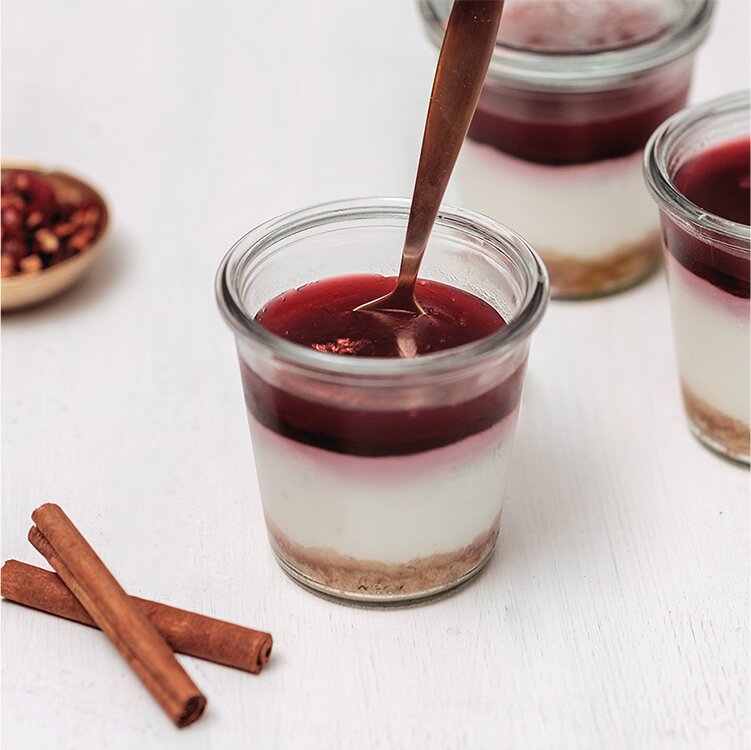 Cheesecake im Glas mit Tee-Topping und goldenem Löffel