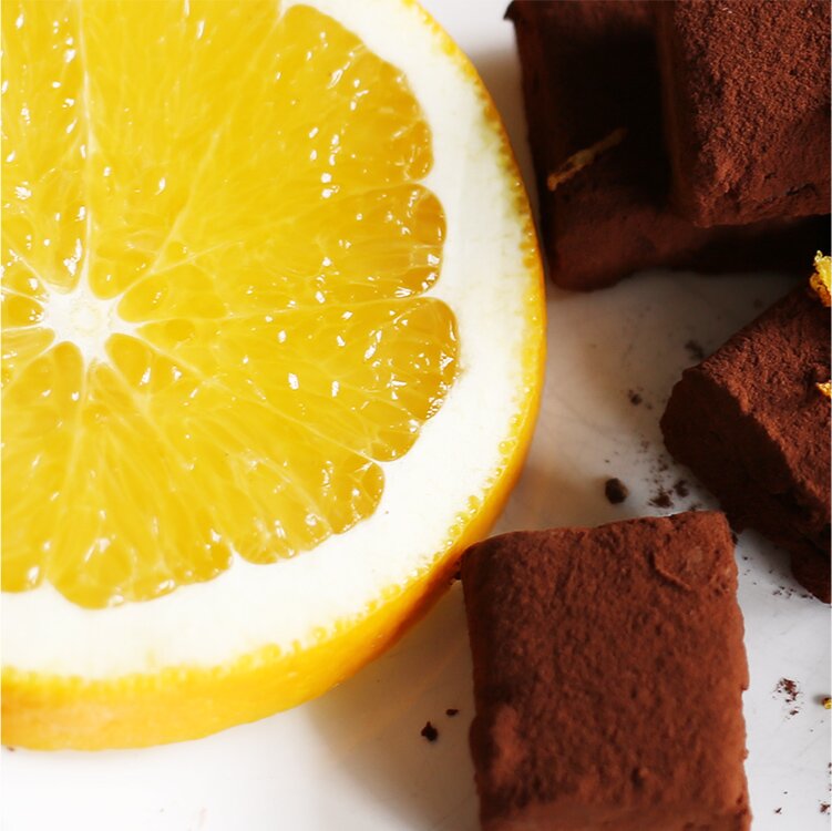 Schokoladenkonfekt mit einer Orange daneben