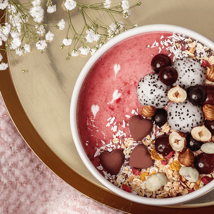 Himbeer-Smoothie-Bowl mit Drachenfrucht und Nüssen als Topping