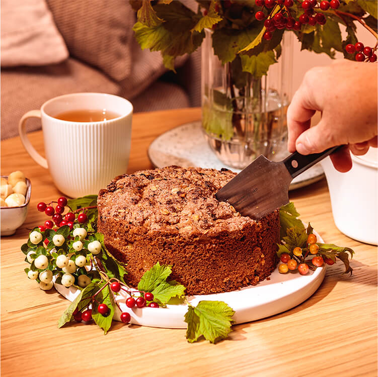 Apple Crumble Cake auf einem Teller wird angeschnitten